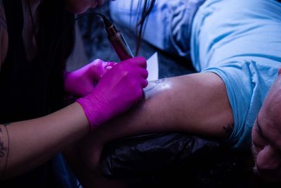 Close-up of tattoo artist tattooing man