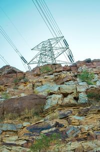 Low angle view of electricity pylon against clear sky