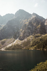 Scenic view of lake by mountains against sky