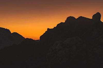 Silhouette rock formations against sky during sunset