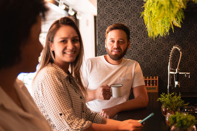 Portrait of smiling friends sitting at home