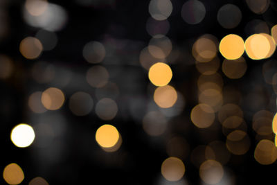 Defocused bokeh lights on black background, abstract blurred backdrop for christmas eve or birthday