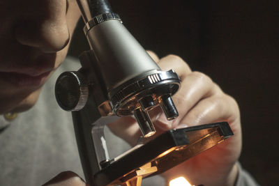 Close-up of man looking through microscope