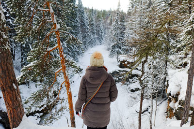 Rear view of man standing on snow covered land