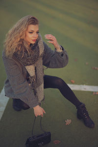 Portrait of young woman sitting on field