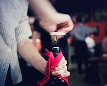 Close-up of man opening a bottle