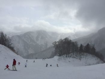 Tourists on snow covered mountain