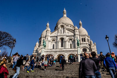 Group of people in temple against blue sky