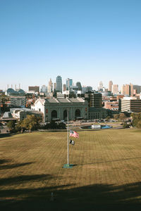 Houses by field against clear sky