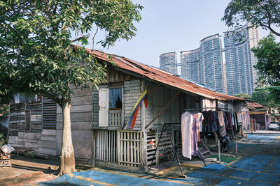 Overall view of old wooden houses with modern buildings in the background in kuala lumpur malaysia.