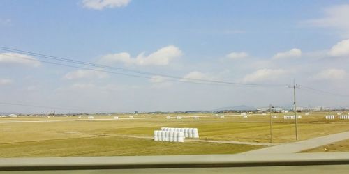 Electricity pylons on landscape against sky