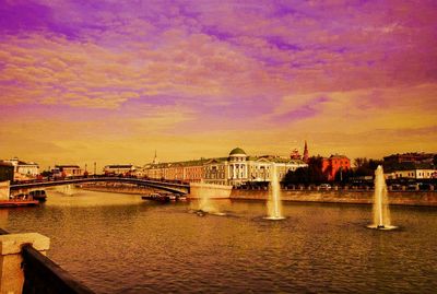 Bridge over river against sunset sky