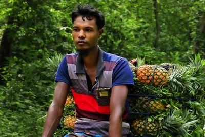 Portrait of young man standing against plants