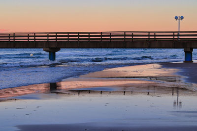 Pier over sea against sky during sunset