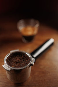 Coffee machine holder on wooden table with espresso glass