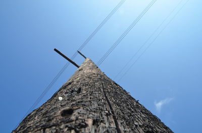 Low angle view of power lines against blue sky