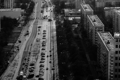 High angle view of vehicles on road by modern buildings during sunny day