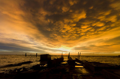 Scenic view of beach against dramatic sky