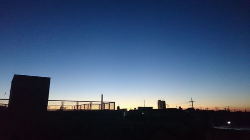 Low angle view of illuminated cityscape against sky at sunset