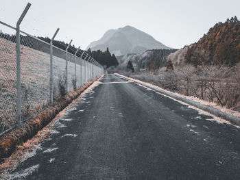 Road by mountains against clear sky