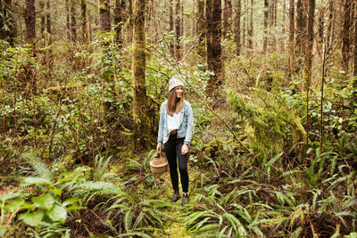 Beautiful woman forages in the rainforest near tofino