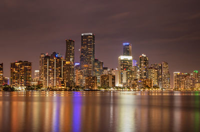 Illuminated buildings against sky at night