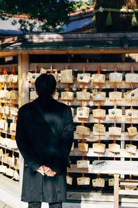 Rear view of man standing at store