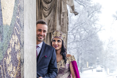 Portrait of happy young couple in park during winter