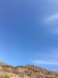 Rock formations on landscape against blue sky