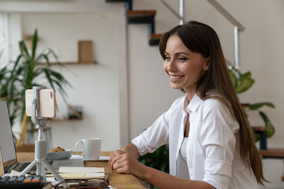 Portrait of smiling young woman on table