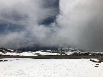 Snow covered landscape against sky