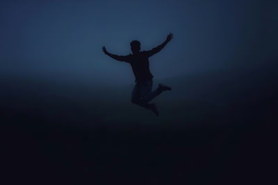 Silhouette man jumping in sea against sky