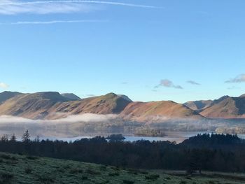 Scenic view of landscape and mountains against blue sky