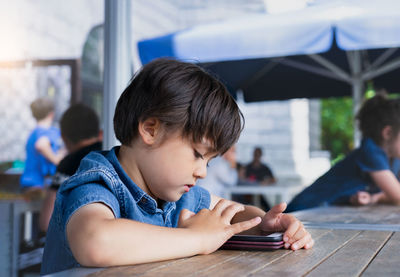 Portrait of boy sitting on table