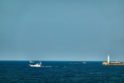 Sailboat sailing on sea against clear sky