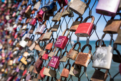 Close-up of padlocks hanging on railing by river