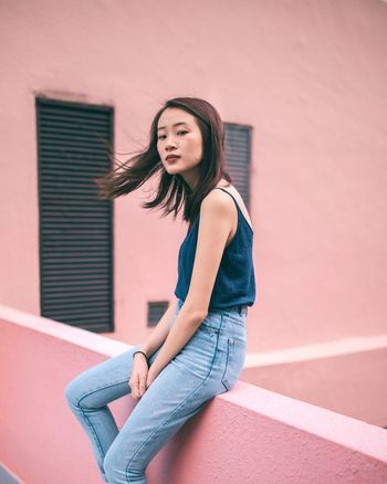 Beautiful young woman against wall