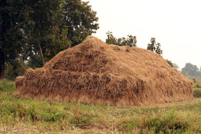Hay bales on field against sky