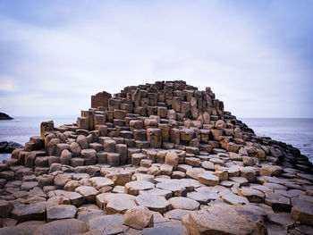 Stack of rocks on beach against sky