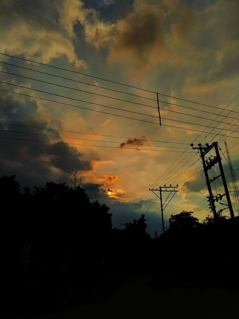 LOW ANGLE VIEW OF SILHOUETTE ELECTRICITY PYLONS AGAINST SKY DURING SUNSET