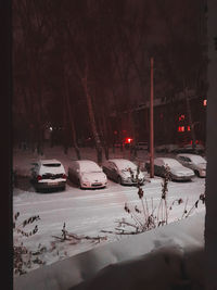 Cars on snow covered street at night