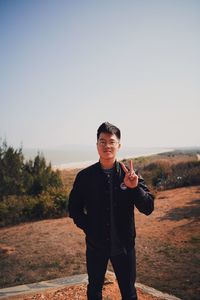 Portrait of smiling man standing against clear sky