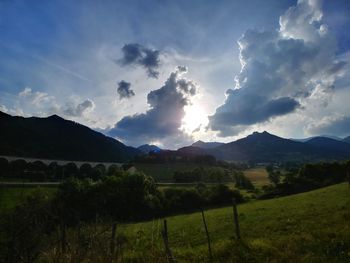 Scenic view of field and mountains against sky