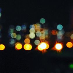 Defocused lights against sky at night