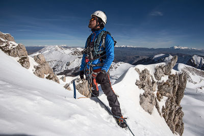 Man on snowcapped mountain against sky