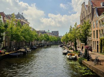 Canal amidst buildings in city against sky