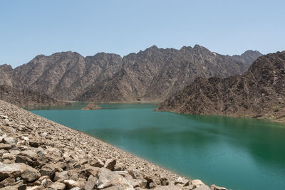 Scenic view of lake and mountains against clear sky