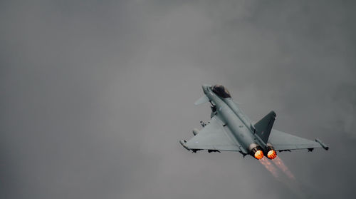 Low angle view of airplane flying against sky