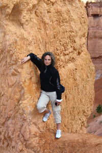 Full length of woman standing by rock formation