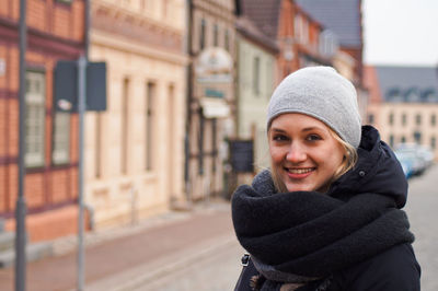 Portrait of smiling woman standing on road in city